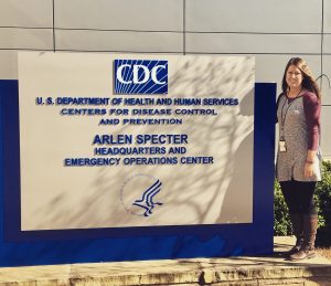 Marissa Thomas standing in front of the sign outside the CDC Washington office
