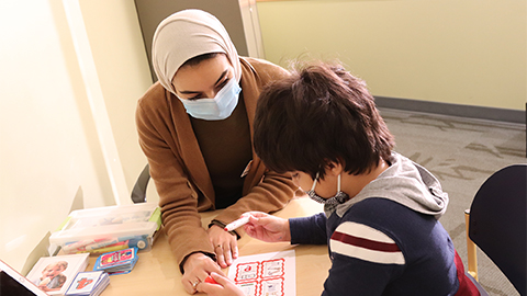 An SLHS student interacts with a pediatric patient.