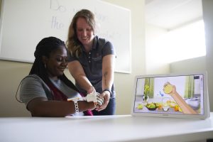 Dr. Proffitt shows research participant how to use assistive technology