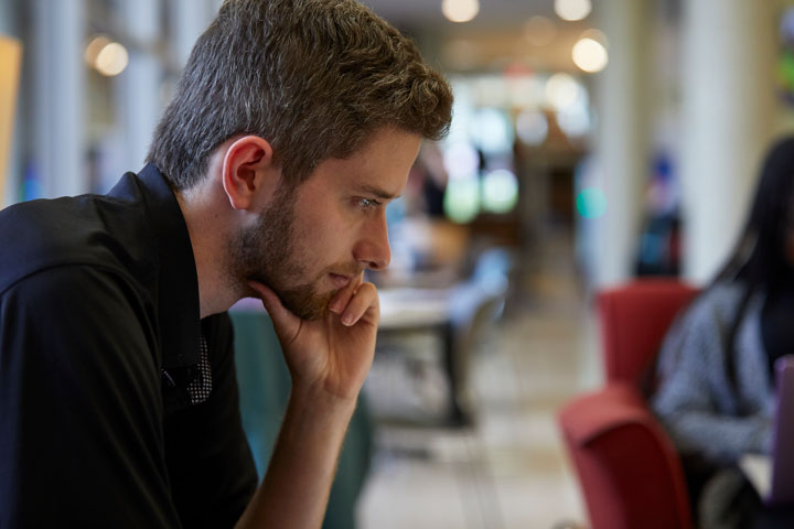 a student studies in the lobby of Clark Hall