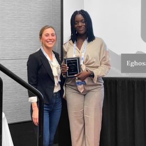 Eghosasere Ogbevoen stands with her award at the American Public Health Association student awards event