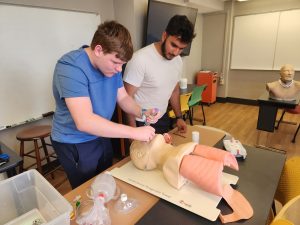 Two students work with an airway management trainer at the University of Missouri.