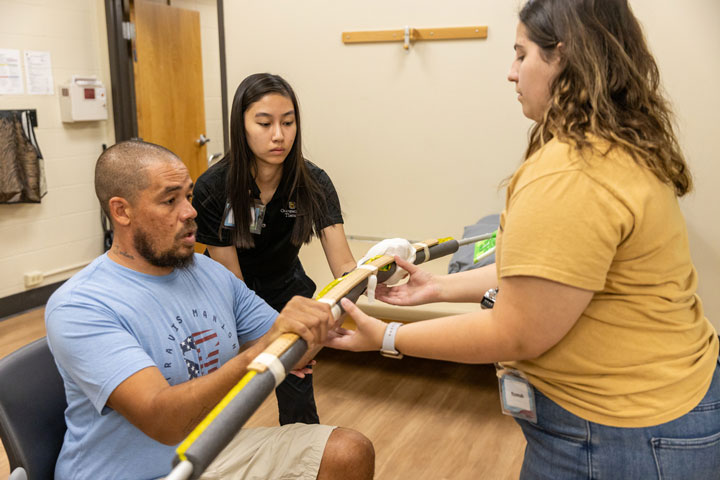 Two women work with a patient in Tiger OT