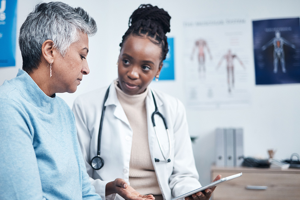 A doctor and patient talk in a clinical setting.