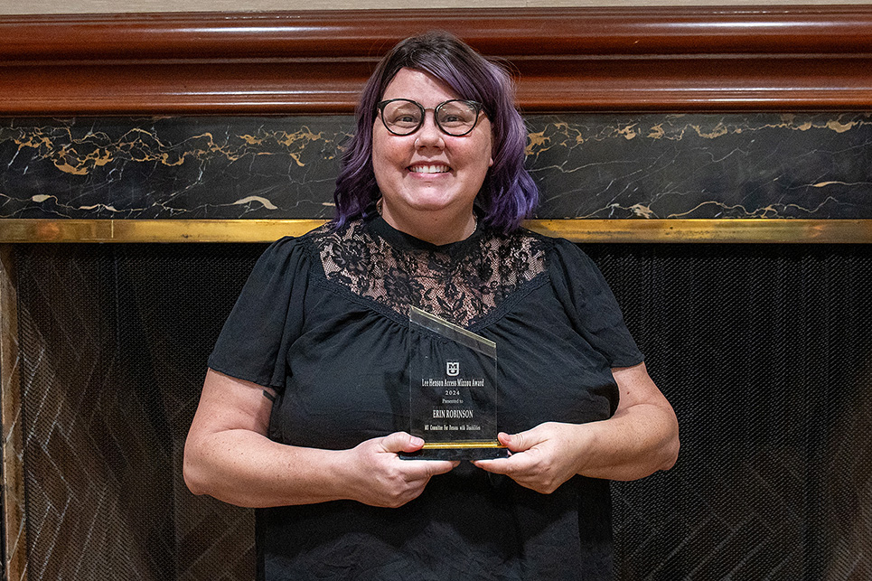 Erin Robinson stands with a Lee Henson Award