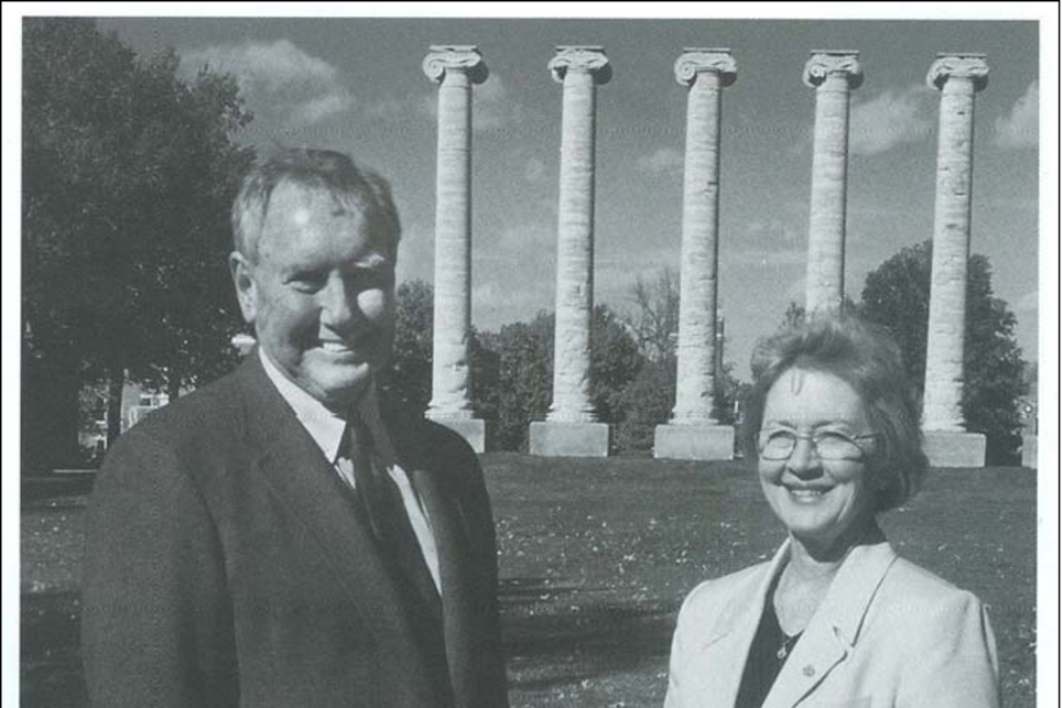 A man and woman stand near the Mizzou columns