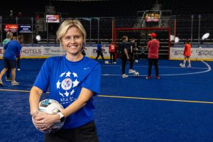 A woman holds a soccer ball