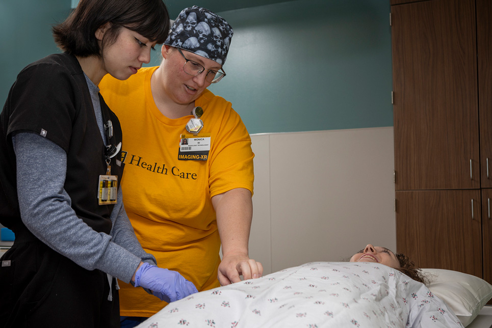 Two women attempt to capture an X-ray image of a patient