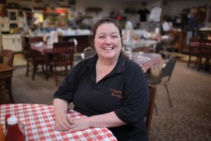 A woman sits at a table in a restaurant