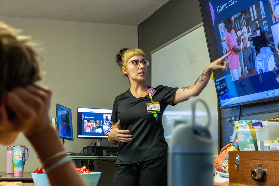 A woman points at a screen
