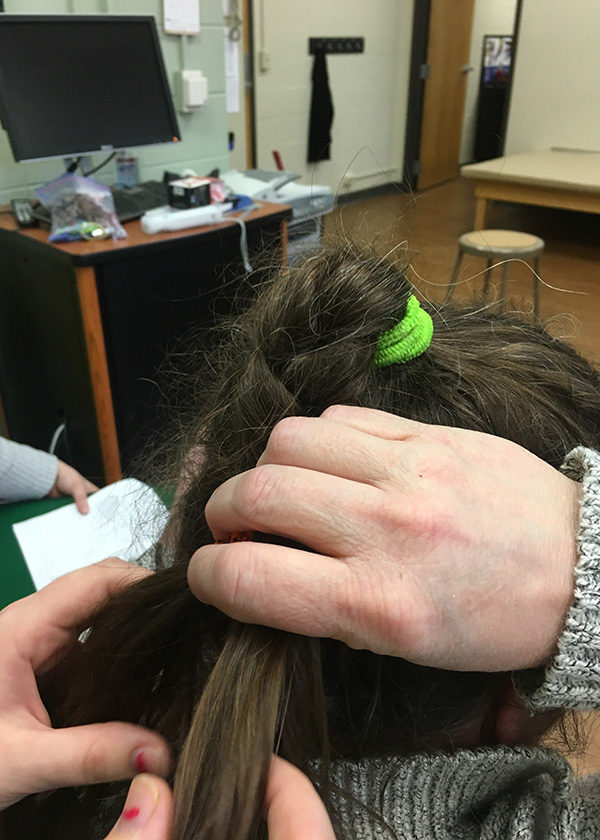 A woman braids her hair