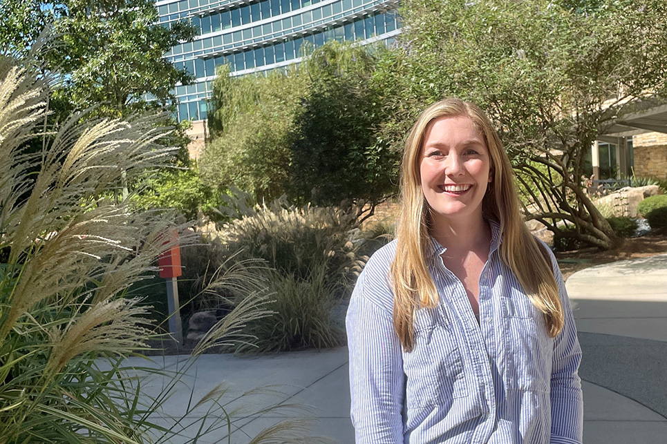 A woman stands in a courtyard surrounded by plants