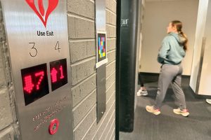 A QR code is taped to a wall near elevators