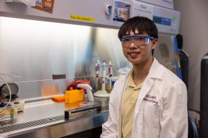 A young man stands in a lab