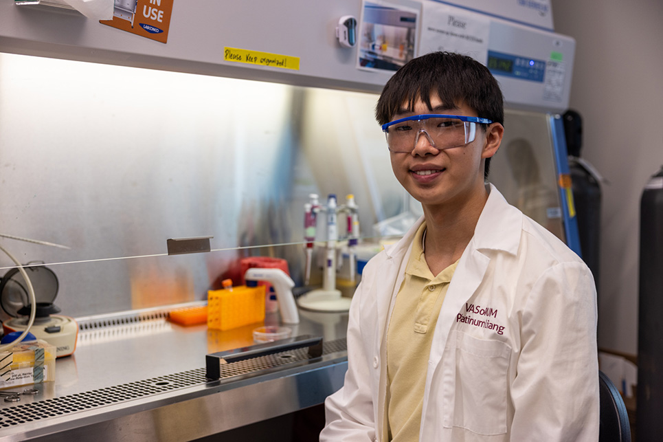A young man stands in a lab