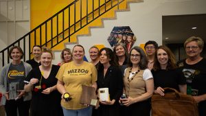 A group of people hold awards