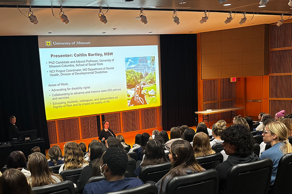 An auditorium full of students listening to a lecture