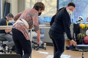 A woman works with a physical therapist