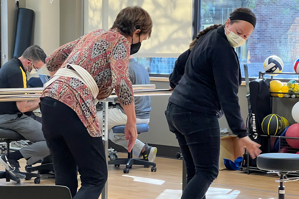 A woman works with a physical therapist